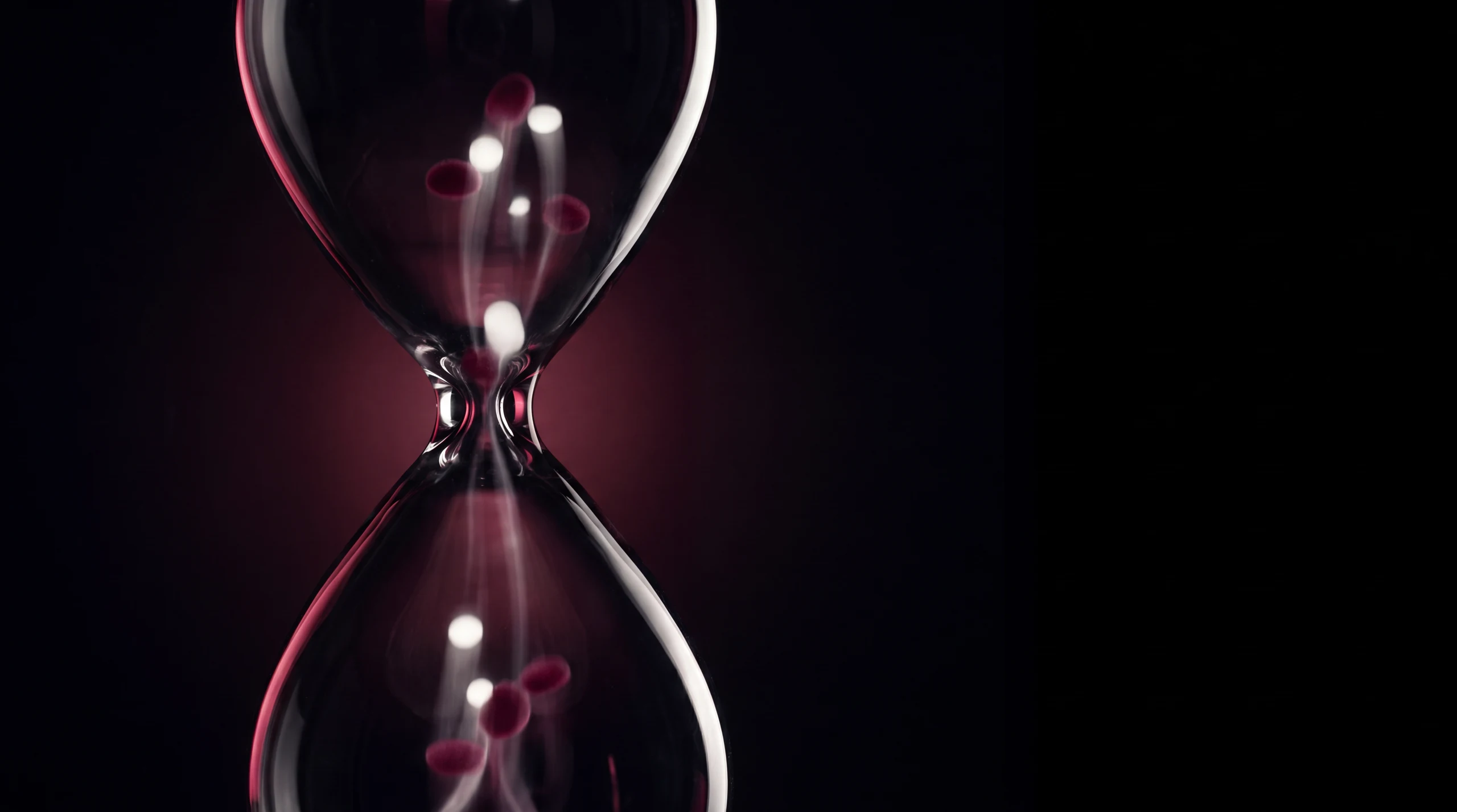Time flowing back upward through a black-glass hourglass